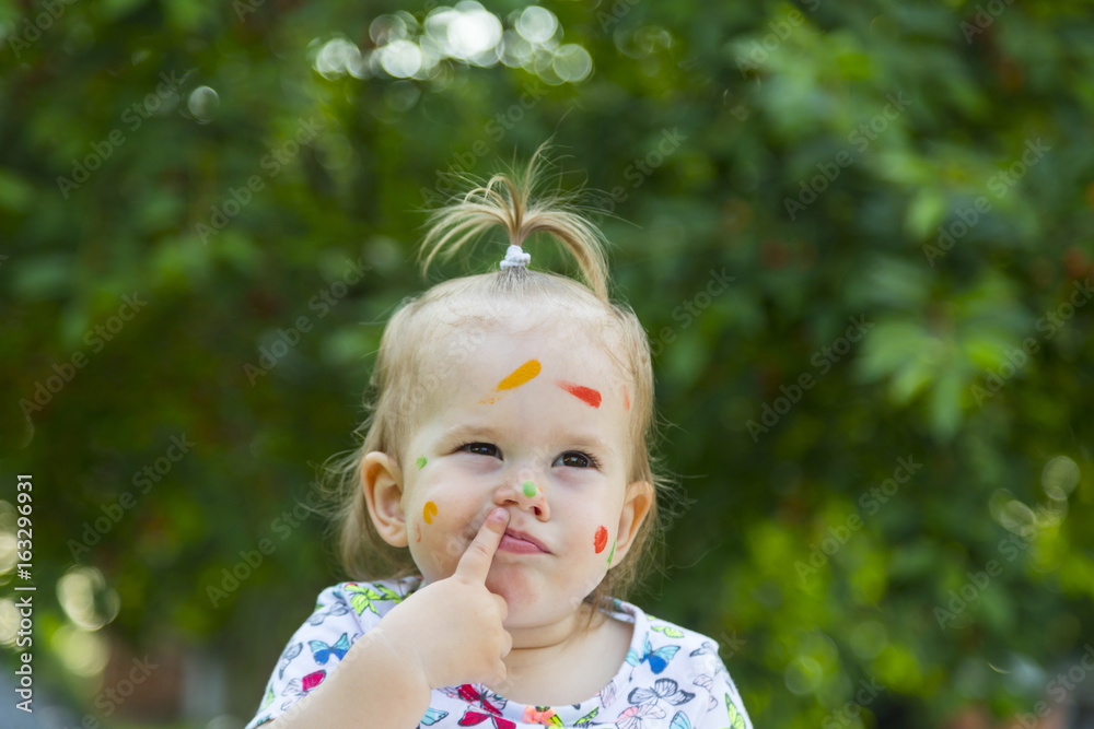 Beautiful baby girl play with colors and learning to draw and painting.