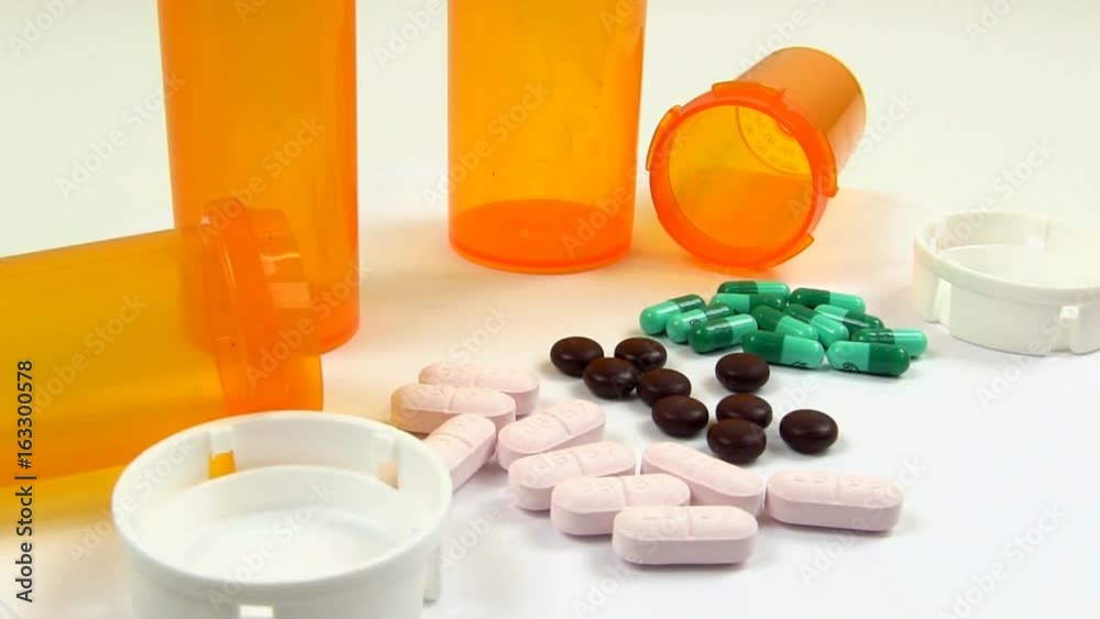 Capsules, pills and tablets rotate into view clockwise while on white ...