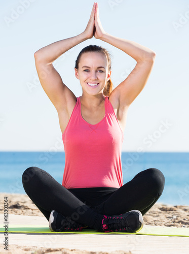 smiling girl exercising on exercise mat outdoor