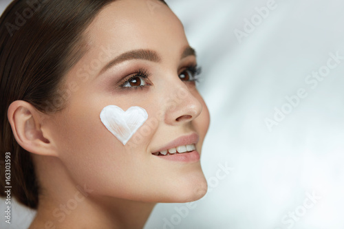 Beauty Skin Care. Woman With Heart Of Cream On Face