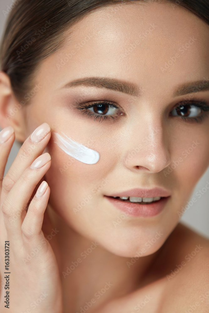 Facial Care. Closup Beautiful Woman Putting Skin Cream On Face
