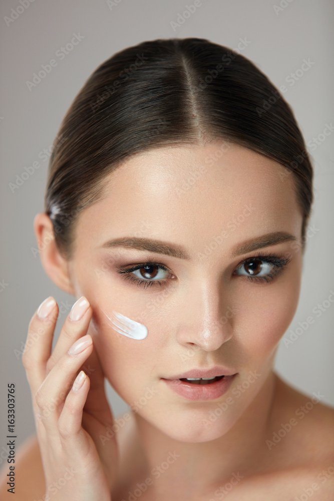 Beauty Cosmetics. Woman Putting Cosmetic Cream On Beautiful Face Beauty Cosmetics. Woman Putting Cosmetic Cream On Beautiful Face