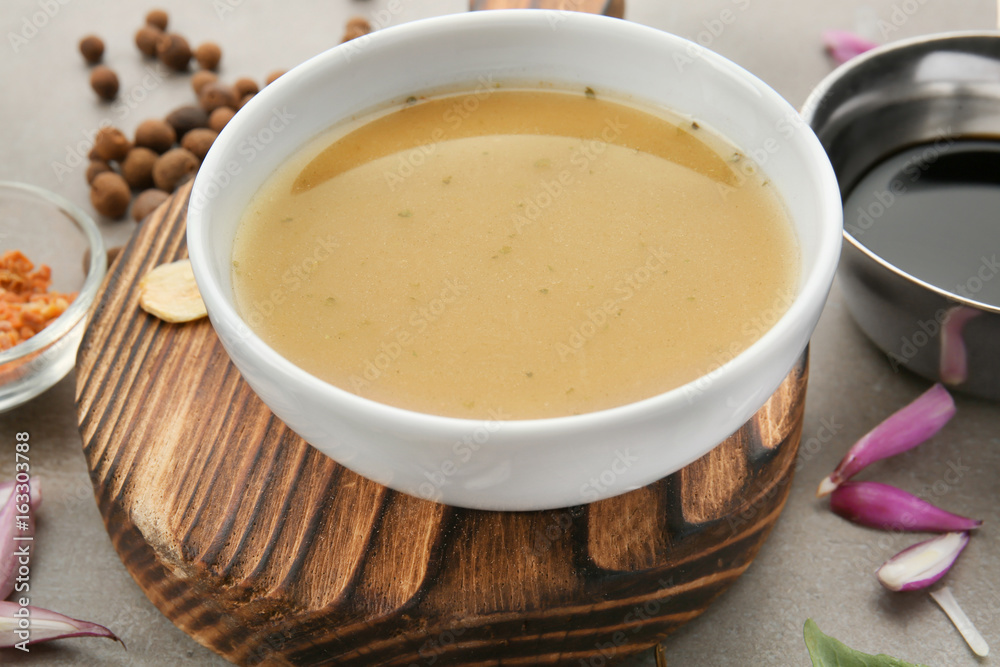 Bowl with turkey gravy and spices on grey table Bowl with turkey gravy and spices on grey table