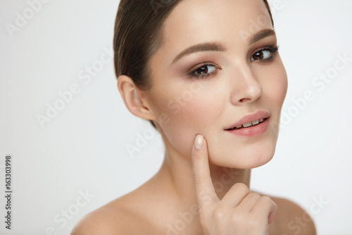 Woman Skin Beauty. Girl With Natural Makeup Touching Skin