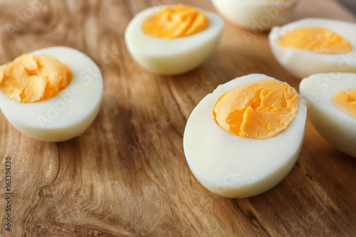 Sliced hard boiled eggs on wooden surface, closeup. Nutrition concept