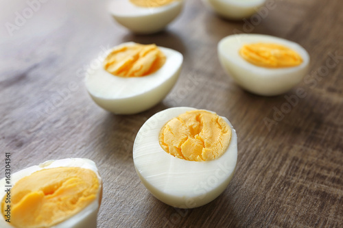 Sliced hard boiled eggs on wooden surface. Nutrition concept