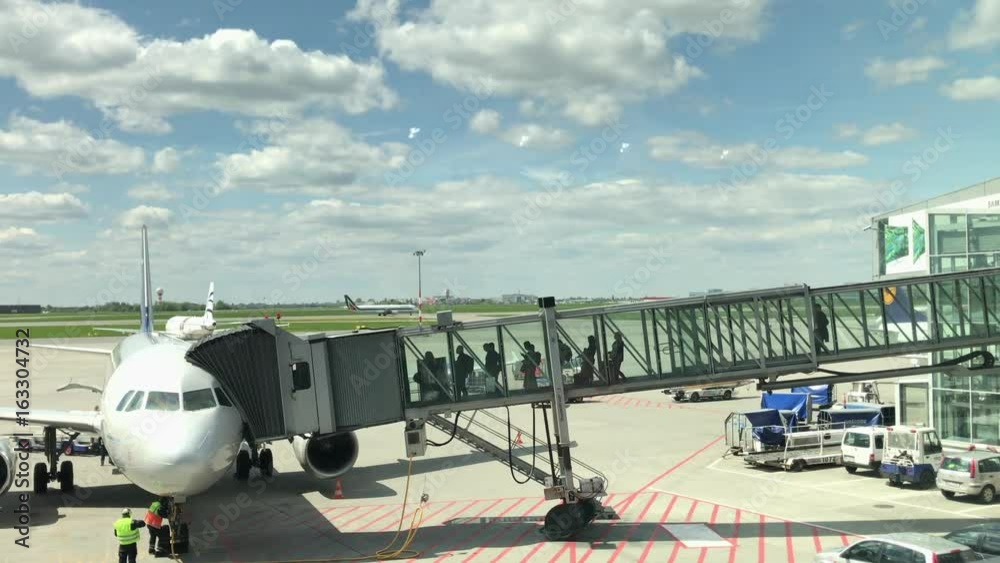 Boarding an airplane at the airport. Long shot