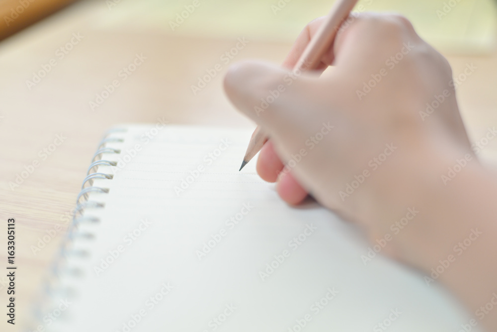 Obraz premium Blurred hand writing on notebook.