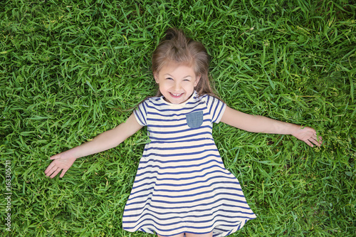 Cute little girl lying on g...