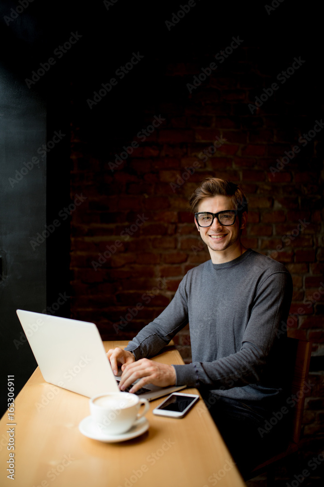 Smiling businessman with laptop beside at the cafe Smiling businessman with laptop beside at the cafe