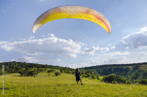 Man running with paragllider, preparing for flight 