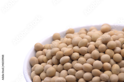 Soy beans on white background high protein Close-up Selective focus seeds Soya bean pulses in a wooden spoon