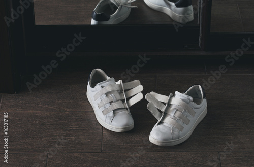 Foto Pair of white shoes on velcro at home