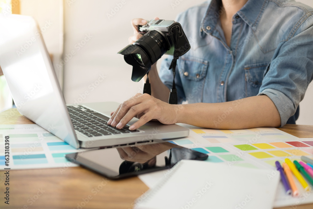Fototapeta premium Photography Ideas Creative Occupation Design Studio Concept, Female photographer sitting on the desk with laptop