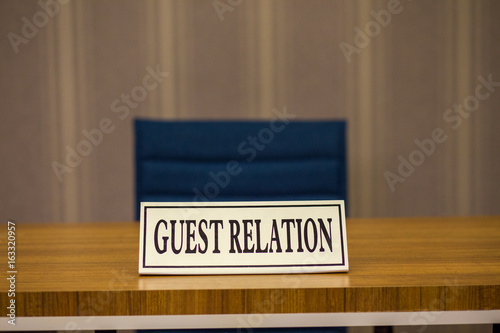 Fototapet The sign with guest relation inscription is on the table