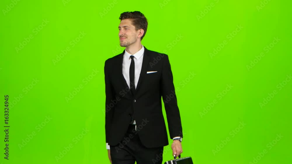 Businessman goes to work, with a diplomat he waves his hand to others. Green screen Businessman goes to work, with a diplomat he waves his hand to others. Green screen