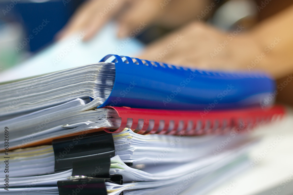 Stack of paper files on work desk in office Stack of paper files on work desk in office
