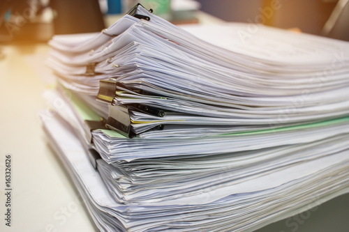 Stack of paper files on work desk in office