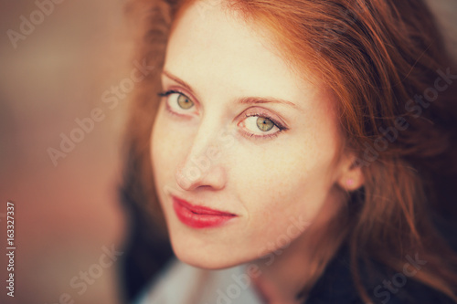 Portrait of a beautiful girl with long red hair 
