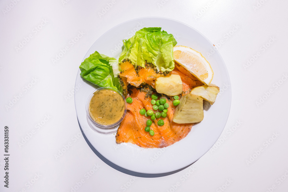 Marinated salmon with green salad on the dish isolated on white background from top-view Marinated salmon with green salad on the dish isolated on white background from top-view