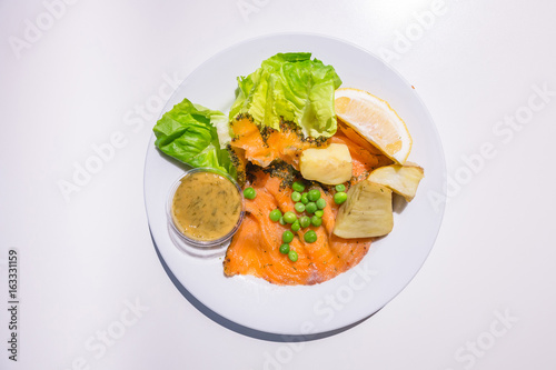 Marinated salmon with green salad on the dish isolated on white background from top-view