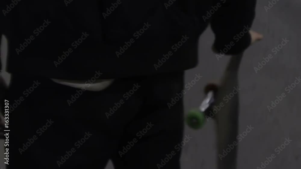 Young man twists a skateboard close-up
