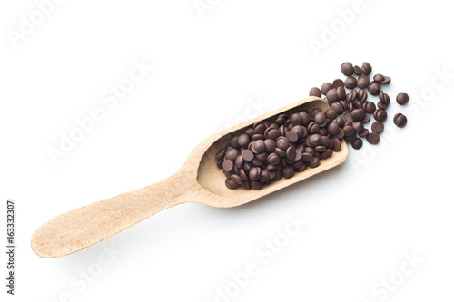 Tasty chocolate morsels in wooden scoop.