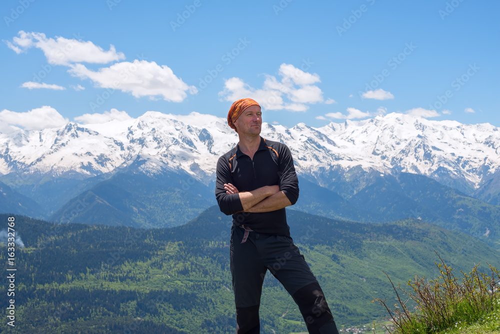 Happy man adventurer stands on a mountains