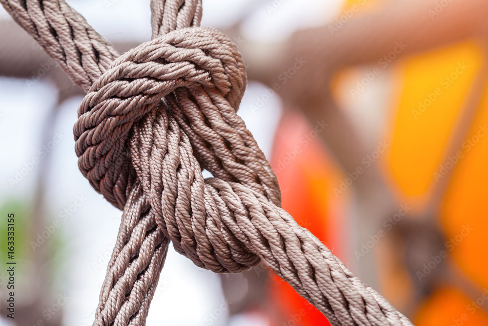 Close-up of rope knot line tied together with playground background