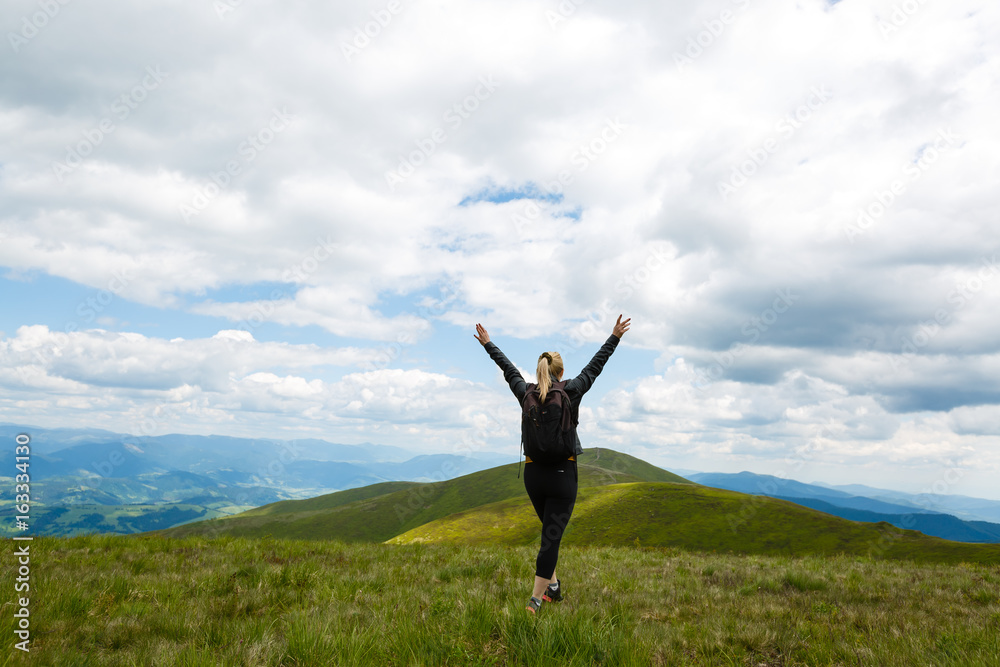 Young woman standing on top of a mountain Young woman standing on top of a mountain