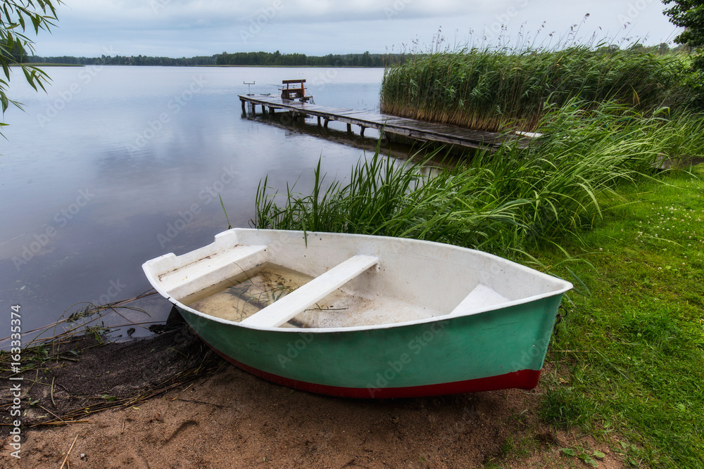 Fisherman's boat and bridge with fishing poles at Masuria lake, Poland