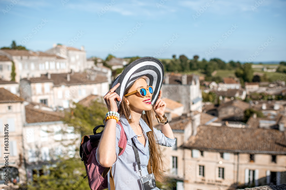 Young woman tourist enjoying beautiful cityscape view on Saint Emilion village in Bordeaux region in France