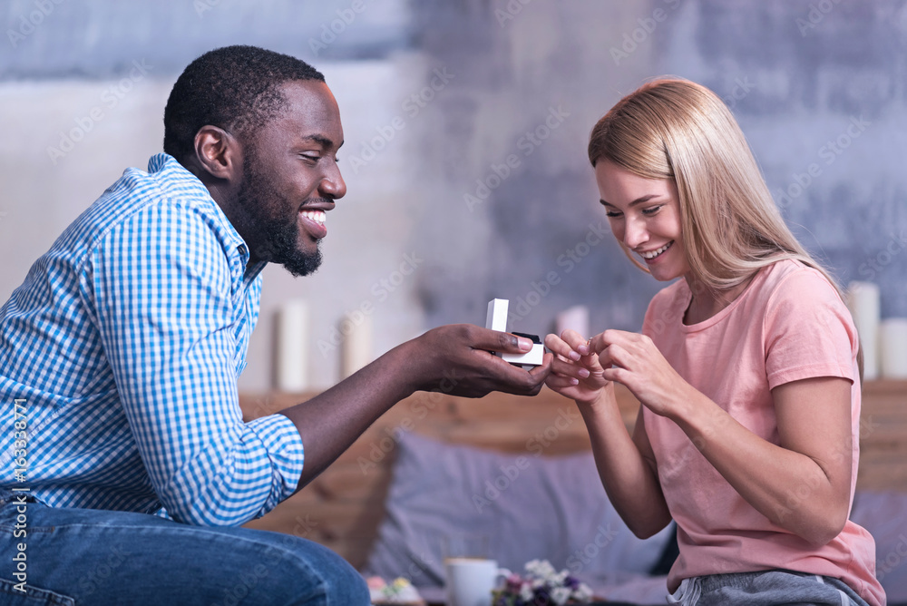 Happy African American couple getting engaged at home