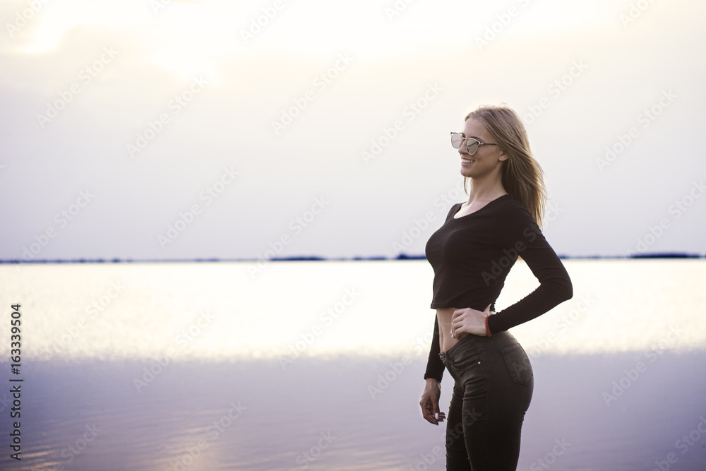 Portrait of young beautiful woman against lake
