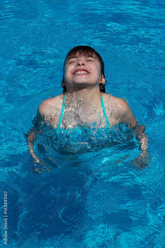 Happy girl dives in the swimming pool