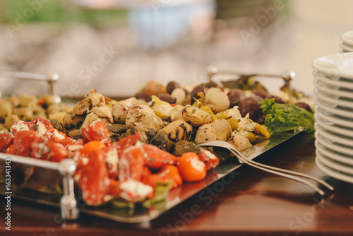 plate with appetizer : artichokes, smoked salmon, peppers, olives , catering