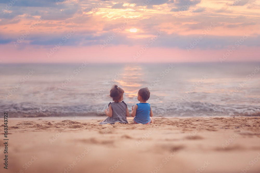 Little boy and girl on the beach at sunset. Summer, ocean, paradise. Outdoor.