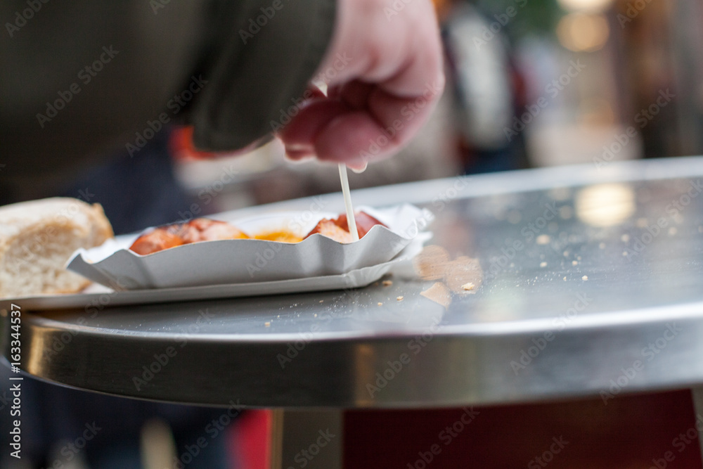 Mann beim Currywurst essen in Fußgängerzone Mann beim Currywurst essen in Fußgängerzone