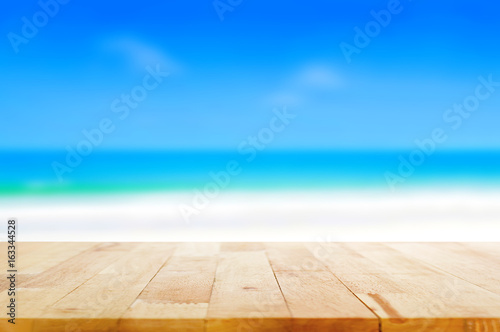 Wood table top on blurred beach background, summer concept