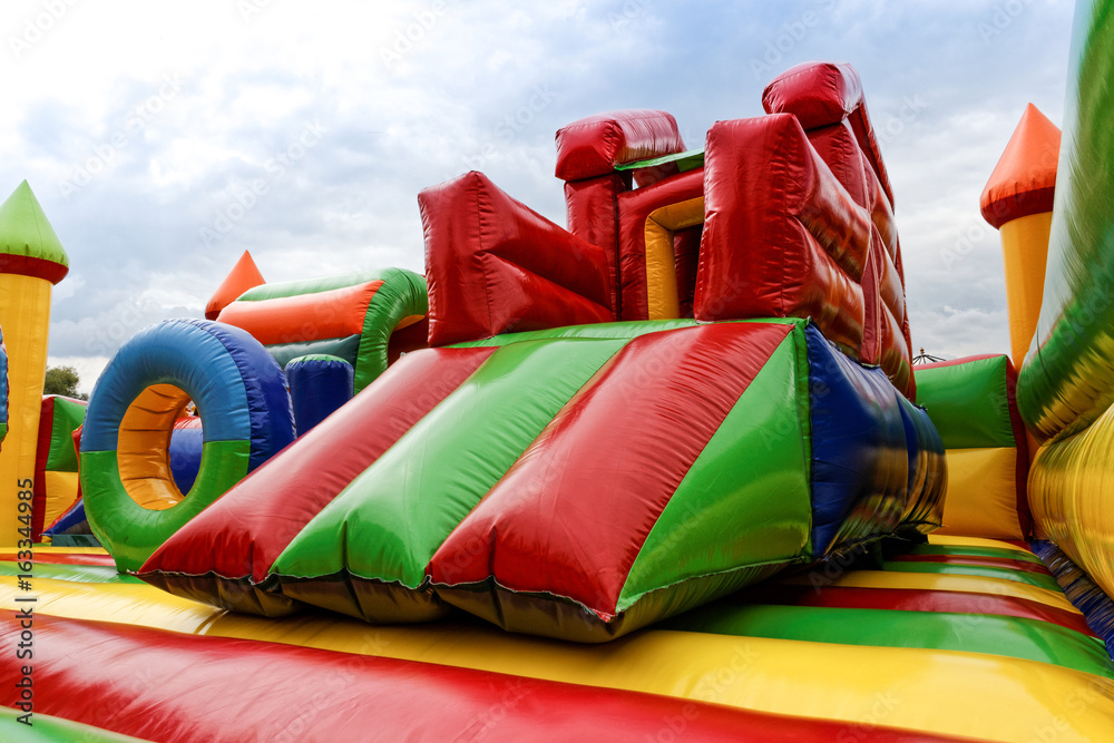 Inflatable slide for kids in playground - obrazy, fototapety, plakaty 
