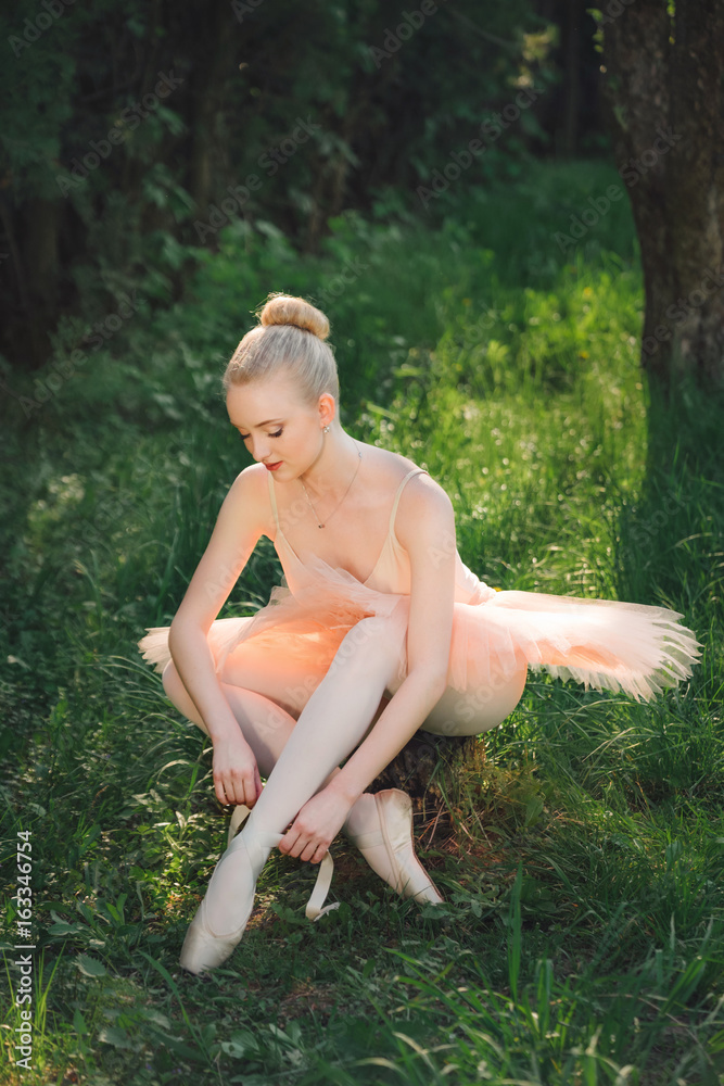 Obraz premium Young ballerina preparing for dance outdoors