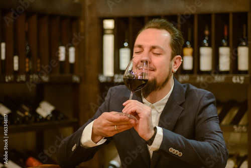 Young sommelier on red wine in cellar
