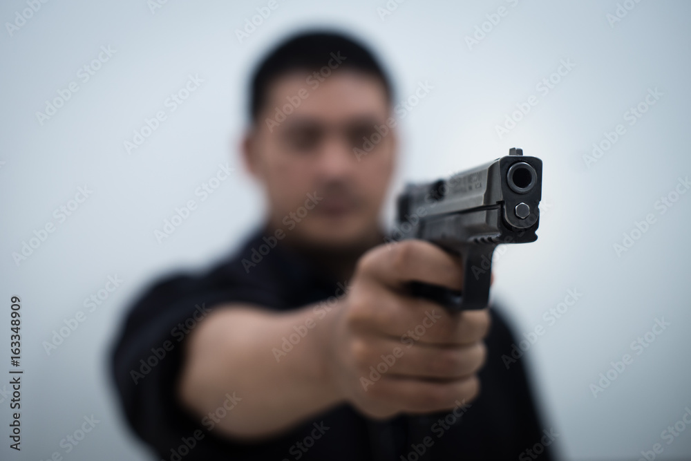 Man pointing gun at the target with one Hand on white background ,selective focus on front gun. Man pointing gun at the target with one Hand on white background ,selective focus on front gun.