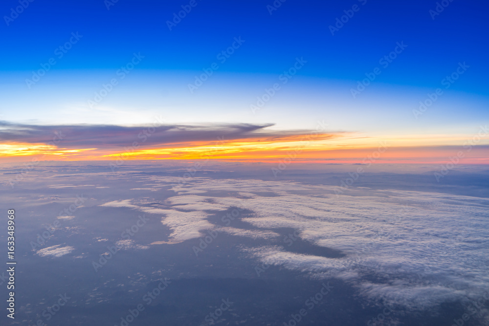 Plane wing on the sky with sunset and cloud, aerial view from airplane window.
