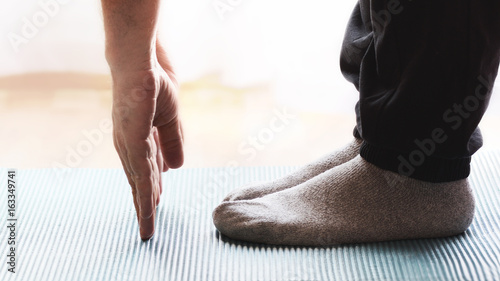 Adult person doing some yoga and meditation exercises on a mat in a class. Empty copy space for Editor s text.