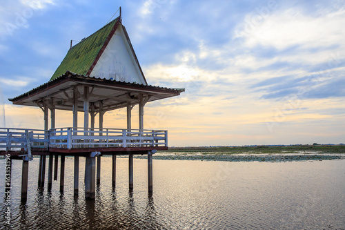 Wooden pavilion at lake with light on evening or sunset tone.