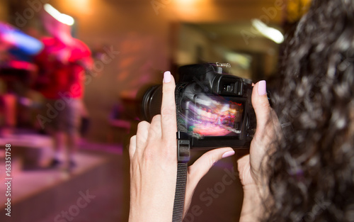 A girl shoots a video on the camera at a concert