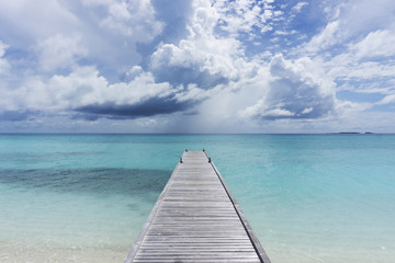 Fotobehang Pier Houten pier boven helderblauwe tropische zee  © ink drop