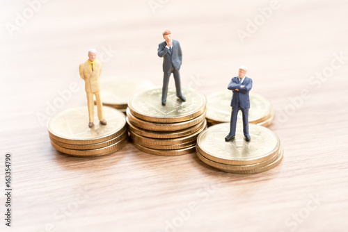 Miniature people standing on stack of coin,Business concept