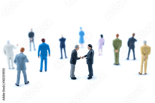 Miniature people shaking hands, Business concept.